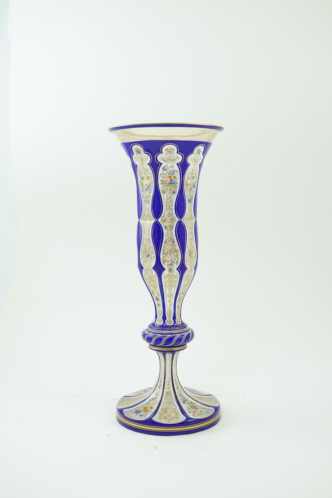 A tall 19th century Bohemian blue and white overlaid gilt and enamel decorated vase in the manner of Moser